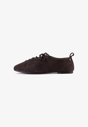 Zapato plano de ante marrón oscuro con cordones delanteros y asa en el talón, diseño minimalista y suela delgada, mostrado en perfil lateral.
