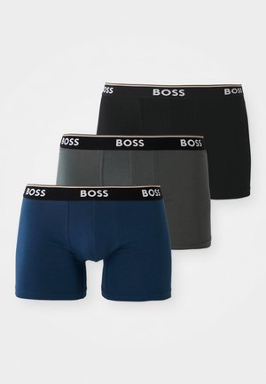 Drei Paare Herren-Boxershorts: navyblau, grau und schwarz, jeweils mit einem schwarzen Bund, der das "BOSS"-Logo trägt. Glattes Baumwollmaterial.