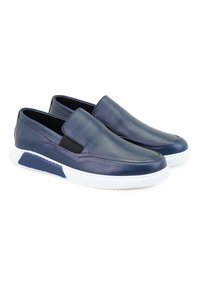 Marineblaue Leder-Slipper mit einer weißen Gummisohle, ausgestattet mit elastischen Seiteneinsätzen und einer glatten Textur. Minimalistisches Design mit genähten Akzenten.