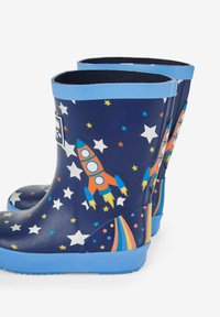 Stivali di gomma blu con sfondo blu navy, decorati con stelle bianche e disegni di razzi colorati, suola texturizzata e bordi elasticizzati.
