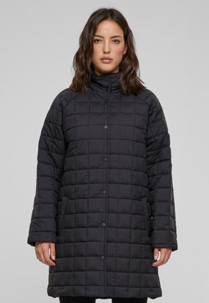 Black, quilted long coat with a high collar and snap buttons, featuring a padded texture and loose fit. Suitable for cool weather.