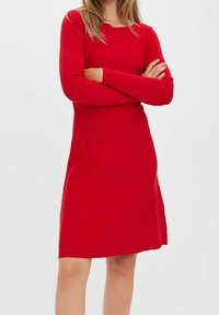 Robe longue rouge à manches longues en tissu doux, avec un col rond et une silhouette ajustée, présentant une texture lisse et une coupe au genou.