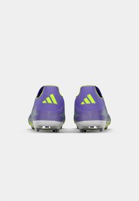Purple soccer cleats with green accents and textured design. Features ribbed upper and clear plastic sole plates with studs for traction.