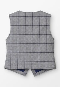 Chaleco gris hecho de un tejido texturizado con un patrón de cuadros azul marino. Presenta un escote redondeado y un diseño de espalda dividida.