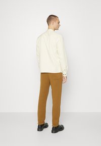 Jack & Jones JJIKANE JJBRINK PANTS - Calças de fato de treino - desert palm