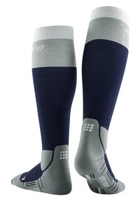 Calze da calcio al ginocchio blu e grigie con texture a coste, suola imbottita e logo sul davanti. Presenta punti di presa sulla suola per una maggiore aderenza.