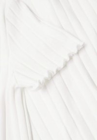 White ribbed fabric with a close-up on a ruffled fold, showing texture and scalloped edge details.