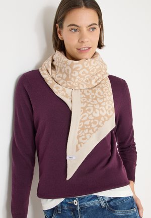 Beige und brauner Leopardenmuster-Schal mit dreieckigem Design, aus weichem Material gefertigt, getragen über einem dunkelvioletten Pullover.