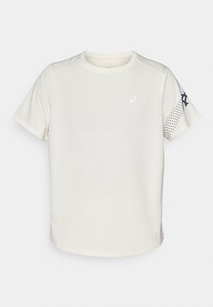 T-shirt sportivo color beige chiaro realizzato in tessuto traspirante. Presenta maniche corte, collo rotondo e un motivo a pois sulla manica destra.