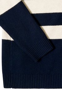 Pull en maille rayé bleu marine et crème avec poignets et ourlet côtelés. Texture douce ; présente de larges rayures horizontales et une coupe décontractée.