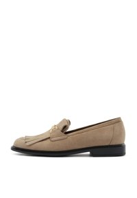 Beige suede instappers met een ronde neus, voorzien van een decoratieve franjerel en een goudkleurig accent; platte zwarte zool voor stabiliteit.