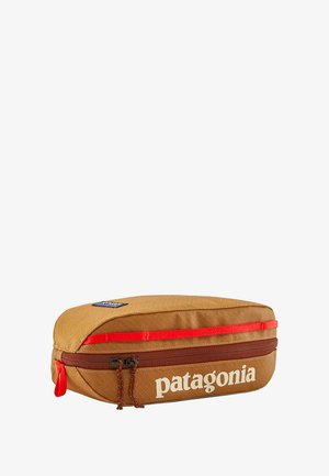 Estuche de lápices Patagonia, forma rectangular, material tejido marrón, cremallera y detalles rojos, logo en texto blanco, superficie texturizada.