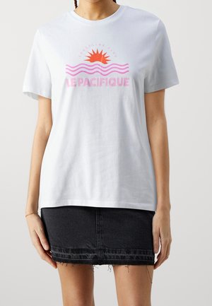 Wit katoenen T-shirt met korte mouwen, met een kleurrijke grafische print van een zon en golven, en de tekst "LE PACIFIQUE" in roze.