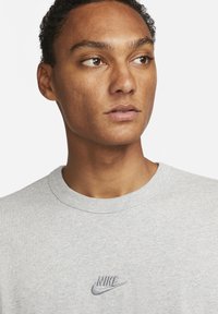 Hallhalli hallitusseente rukki, mis on valmistatud puuvillasegusest kangast. Ees on kontrastse värviga tikitud Nike'i logo.