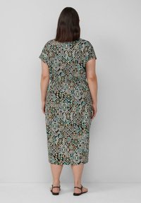 Midikleid mit geometrischem Muster in Braun, Türkis und Creme. Kurze Ärmel und eine lockere Passform mit cinchtem Bund.
