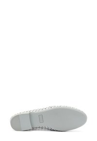 Scarpa bianca a slip-on intrecciata con una tomaia testurizzata, suola piatta e logo discreto sul tallone. Design leggero adatto per un abbigliamento casual.