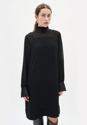 Schwarzes Langarmkleid mit hohem, gerafftem Kragen, durchsichtigen Ärmeln und solidem Saum. Verfügt über eine lässige Passform und eine glatte Textur.