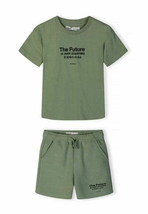 Zestaw składający się z zielonej koszulki z krótkim rękawem i szortów z elastyczną talią, z czarnym napisem "Przyszłość właśnie się zaczyna" oraz koreańskimi znakami na obu elementach.