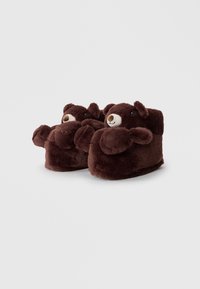 Brown plush bear slippers featuring a rounded shape, bear face, ears, and small arms. Soft texture with a solid color and minimal detailing.