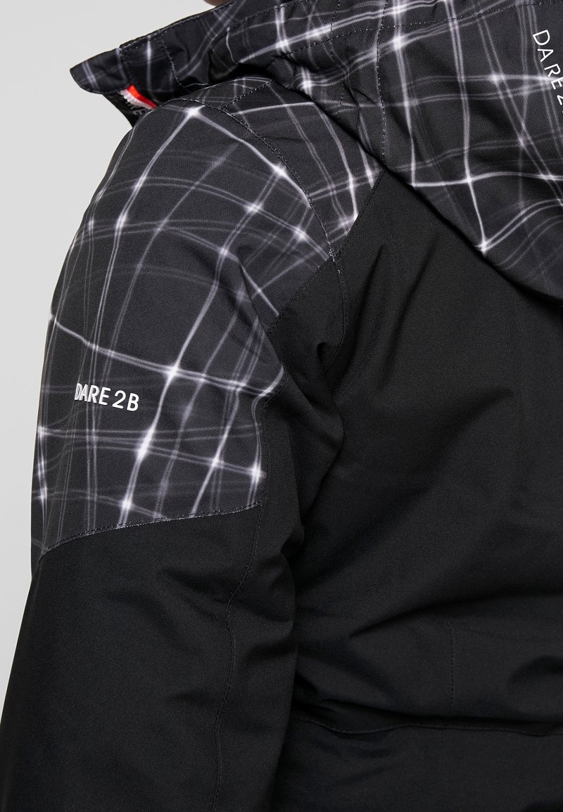 Schwarze Jacke mit einem gesteppte schwarz-weißen Karomuster auf den Schultern. Mit dem "Dare 2B"-Logo in Weiß. Weicher Stoff.