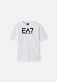 Bijela pamučna majica s crnim zakovikama s logom "EA7 EMPORIO ARMANI" sprijeda, kratkim rukavima i okruglim izrezom.