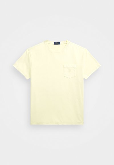 Gaiši dzeltena kokvilnas T-kreklu ar apaļu kaklu un īsām piedurknēm, ar krūšu kabatu un mazu logo uz kabatas.