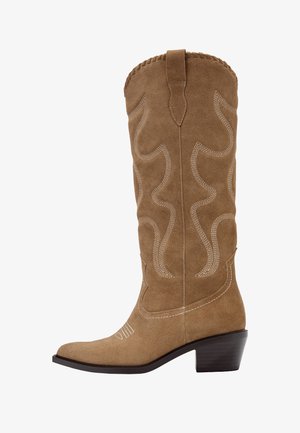 Brązowy kowbojski but zamszowy do połowy łydki z dekoracyjnym białym ściegiem i grubym, warstwowym obcasem.