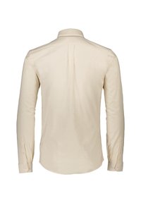Camicia beige a maniche lunghe con colletto classico, dettaglio della piega posteriore, orlo curvo e polsini con bottone. Tessuto dalla texture liscia.