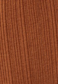 Ribbed fabric in a warm brown color, featuring a textured surface with vertical lines. Material appears soft and stretchy.