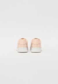 Pink synthetic sneakers with a smooth texture, white rubber soles, and rounded backs featuring a subtle scalloped detail.