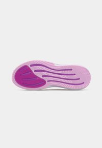 Suola di una scarpa da ginnastica rosa e viola con motivi di presa testurizzati e scanalature curve per trazione su uno sfondo bianco.
