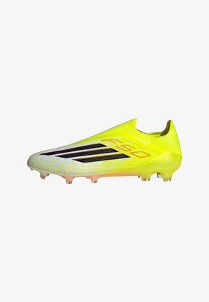 Bright yellow soccer cleat with a sleek design, textured upper, black stripes, and transparent studs. Lightweight and aerodynamic shape.