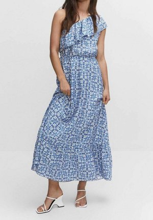 Abito maxi in blu e bianco con un motivo floreale, design a spalla unica con dettagli a volant, tessuto leggero, abbinato a tacchi bianchi con cinturini.