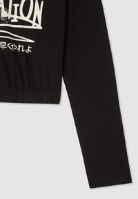 Czarna krótka koszula z długim rękawem wykonana z bawełny, z elastycznym dołem, wyraźnym białym nadrukiem i miękką fakturą.