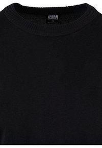 Zwarte gebreide pullover trui met een ribbelige ronde hals en een zachte textuur. Etiket zichtbaar, met het merk "Urban Classics" en maat XS.