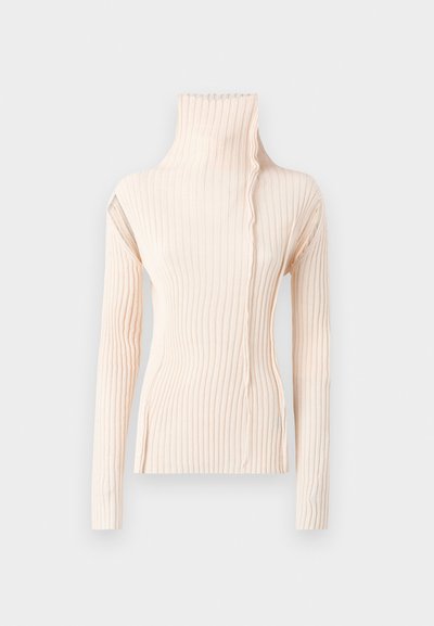 Ριμπέ περίχου ασύμμετρο μπεζ. Διαθέτει μακριά μανίκια και μοναδικό κυματιστό σχέδιο κατά μήκος του λαιμού, κατασκευασμένο από μαλακό ύφασμα πλέξης.