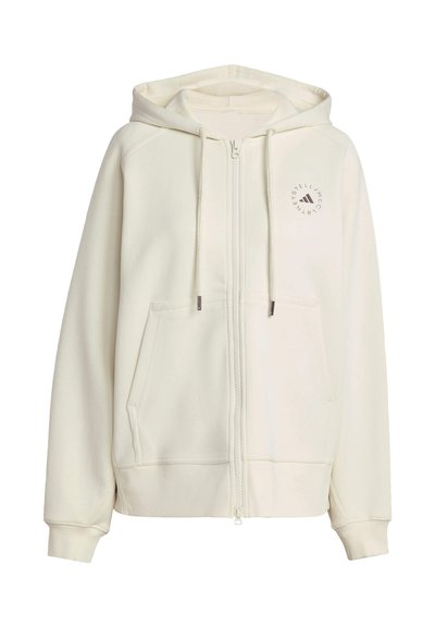 Felpa zip in colore crema realizzata in materiale morbido. Presenta una tasca frontale, cappuccio con cordini e logo circolare sulla parte sinistra del petto.