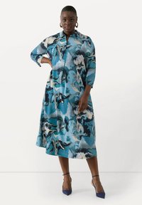 Abito midi fluido in blu con un motivo marmorizzato, colletto e maniche a tre quarti. Tessuto morbido con silhouette rilassata.