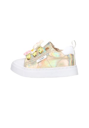 Kindersneaker met iriserend goud, witte zool en hielstuk, gele veters en decoratieve roze en witte zachte speelgoed eraan bevestigd.