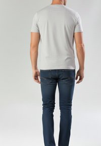 Camiseta de manga corta de color gris claro con cuello redondo, combinada con jeans azul oscuro de corte ajustado que presentan costuras contrastantes y detalles en los bolsillos.