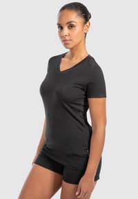 Sort v-hals t-shirt lavet af blødt, strækbart stof med korte ærmer og en figursyet silhuet. Accentmærke ved kanten.