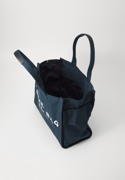 Saco tote de lona azul marinho com uma forma estruturada, apresentando duas alças, um interior preto e texto branco na frente.