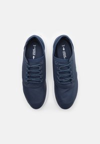 Navy blue athletic shoes with a textured mesh upper, round toe, white sole, and contrasting laces. Features subtle logo detail on the side.