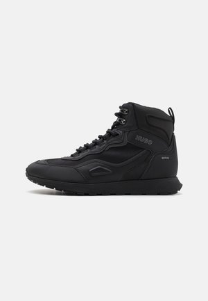 Sort high-top sneaker med snørelukning, strukturerede paneler og "HUGO" branding på siden samt "EST. 93" nær hælen.