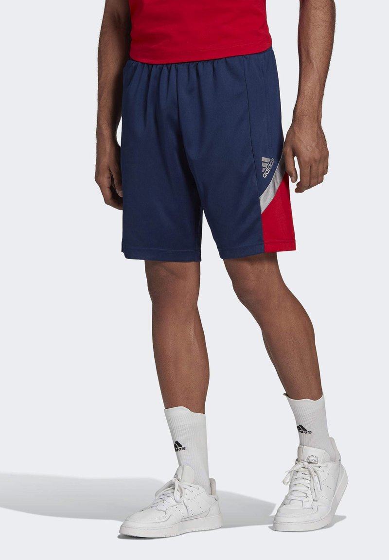 Granatowe szorty sportowe z czerwonymi akcentami i srebrnym paskiem. Wykonane z lekkiego materiału, z elastycznym pasem dla wygody.