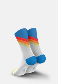 Bunt gemusterte Socken mit einem blauen oberen Abschnitt, weißem Körper und diagonalen Streifen in Rot, Orange und Gelb. Blaue Akzente an Ferse und Schuhspitze.