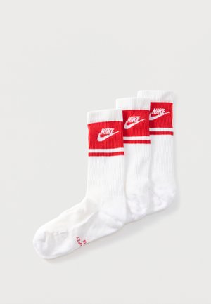 Tre hvide crew-sokker med røde kanter med Nike-logoet og to vandrette striber under logoet.