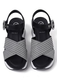 Sandali neri e silver con cinturini a intreccio, una fibbia decorativa e suole imbottite. Materiale: pelle e tessuto.