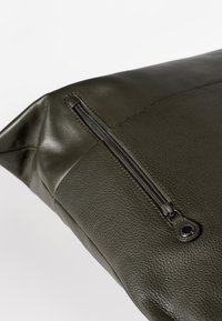 Groene leren tas met een gestructureerde afwerking, voorzien van een zijrits en een glad paneelontwerp.