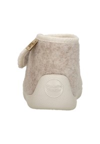 Beige vilten pantoffel met een zacht gestructureerd lichaam, witte rubberen zool en een klein decoratief label aan de zijkant. Achteraanzicht toont een afgeronde vorm.